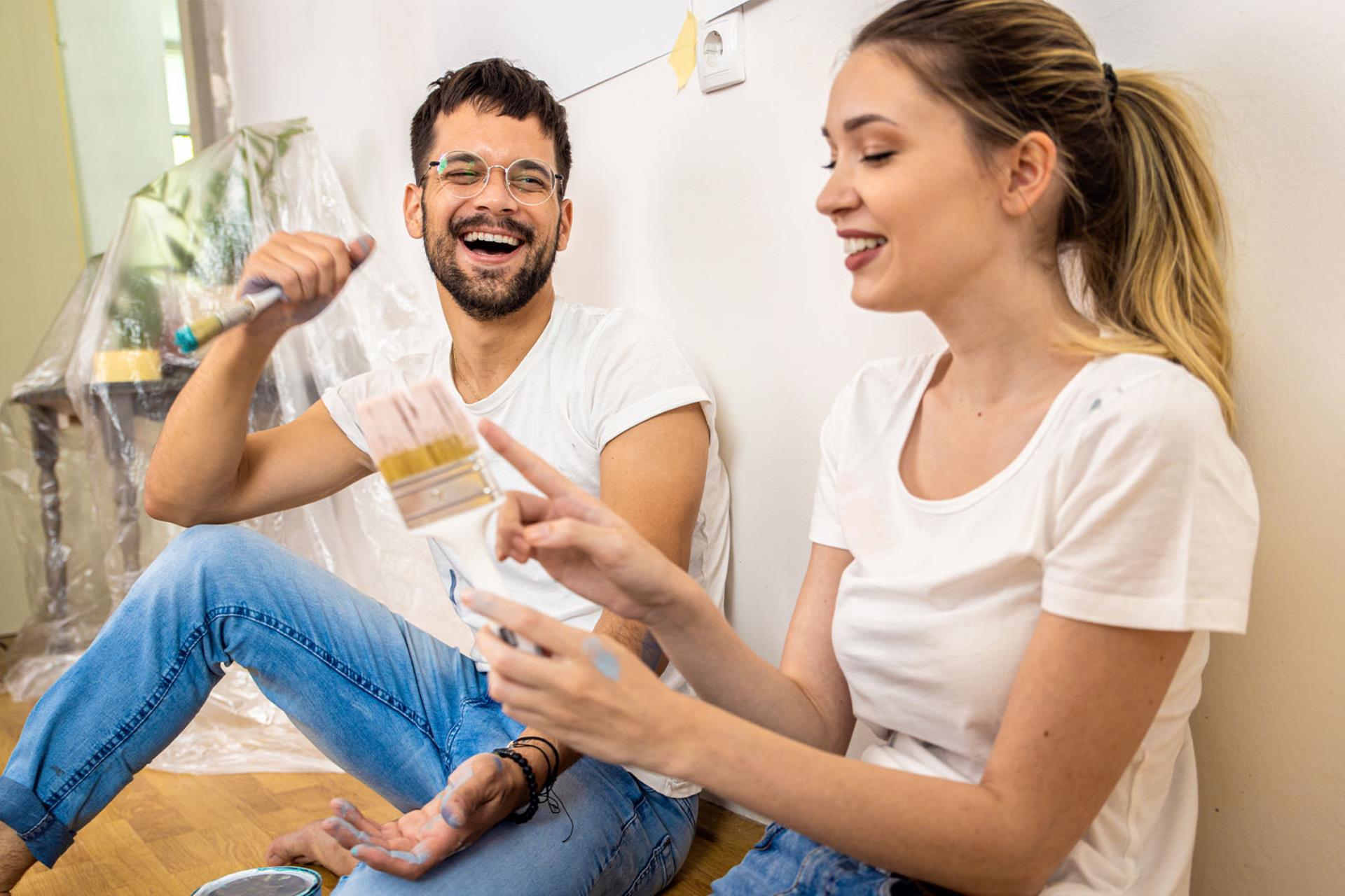 young couple sat on the floor of their first home